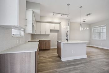 a white kitchen with a large island in the middle of it at The Falls of Portofino Apartment, Florida, 34119